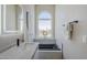 Relaxing bathroom featuring a soaking tub, modern fixtures, and large window with golf course view at 7535 W Kimberly Way, Glendale, AZ 85308