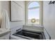 Bathroom featuring soaking tub, modern fixtures, and a window offering outdoor views at 7535 W Kimberly Way, Glendale, AZ 85308