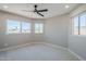 Bright bedroom featuring neutral walls, carpet floors, ceiling fan, and three windows with lovely views at 7535 W Kimberly Way, Glendale, AZ 85308