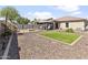 Extensive backyard with gravel, an outdoor fire pit, gazebo seating area, and lush green plants at 7575 W Darrel Rd, Laveen, AZ 85339