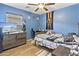 A cozy, blue themed bedroom with wood floors, a large window, and a desk for a work or study space at 7575 W Darrel Rd, Laveen, AZ 85339