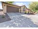 Exterior shot of a beige one-story home with a two-car garage, desert landscaping and a tile roof at 7575 W Darrel Rd, Laveen, AZ 85339