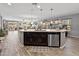 Open concept featuring a kitchen island with pendant lights, stainless steel appliances, and hardwood flooring at 7575 W Darrel Rd, Laveen, AZ 85339