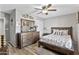 A spacious bedroom with hardwood floors, ceiling fan, dresser and queen bed with stylish floral comforter at 7575 W Darrel Rd, Laveen, AZ 85339
