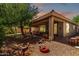 Covered patio and landscaped backyard with a fire pit, perfect for outdoor gatherings and relaxation at 7617 E Desert Honeysuckle Dr, Gold Canyon, AZ 85118