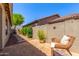 Backyard patio area with stone pathway, mature landscaping, and cozy outdoor seating at 7617 E Desert Honeysuckle Dr, Gold Canyon, AZ 85118