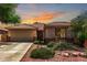 Inviting single-story home featuring desert landscaping and a tile roof, set against a vibrant sunset sky at 7617 E Desert Honeysuckle Dr, Gold Canyon, AZ 85118