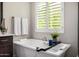 Bathroom featuring white tub and plantation shutters at 8055 E Jaeger St, Mesa, AZ 85207