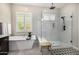 Bathroom featuring white tub and glass shower, and black fixtures with plantation shutters at 8055 E Jaeger St, Mesa, AZ 85207