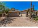 Beautiful beige home featuring desert landscaping, a tile roof, and a brick-paved driveway at 8055 E Jaeger St, Mesa, AZ 85207