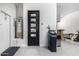 Spacious garage featuring a water heater, sleek black door, and water softener system at 8055 E Jaeger St, Mesa, AZ 85207