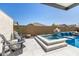 Relaxing hot tub with waterfall feature and fire pit is surrounded by a decorative patio and privacy fence at 8055 E Jaeger St, Mesa, AZ 85207