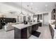 Kitchen island with modern appliances, seating, and a view into the connected living room area at 8055 E Jaeger St, Mesa, AZ 85207
