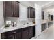 Functional laundry room with dark wood cabinets, white countertops, and natural light at 8055 E Jaeger St, Mesa, AZ 85207