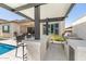 Outdoor kitchen featuring bar seating, counter space and built-in grill and beverage cooler, next to inground pool at 8055 E Jaeger St, Mesa, AZ 85207