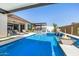 This stunning pool features a waterfall, integrated spa, and an outdoor kitchen, perfect for entertaining and relaxation at 8055 E Jaeger St, Mesa, AZ 85207
