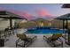 Backyard oasis featuring a luxurious pool with waterfall features, lighting and lounge chairs at 8055 E Jaeger St, Mesa, AZ 85207