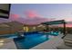 Luxurious pool area featuring a sleek design, waterfalls, and ambient lighting for evening enjoyment at 8055 E Jaeger St, Mesa, AZ 85207