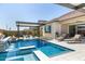 Resort style pool with in ground hot tub, bar seating, outdoor kitchen and adjacent lounge seating at 8055 E Jaeger St, Mesa, AZ 85207
