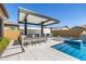Backyard pool with an integrated spa, fire feature, and outdoor bar under a modern pergola, perfect for entertaining at 8055 E Jaeger St, Mesa, AZ 85207