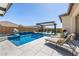 Stunning backyard pool area featuring a waterfall, fire bowls, sun loungers, and a shaded pergola with comfortable seating at 8055 E Jaeger St, Mesa, AZ 85207