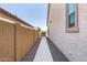 Exterior side yard with rock and stone pathway leading to backyard, lined with neutral stucco wall at 8055 E Jaeger St, Mesa, AZ 85207