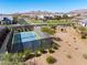 An aerial view of a tennis court nestled within a community, surrounded by desert landscaping and mountain views at 8055 E Jaeger St, Mesa, AZ 85207