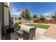 A cozy backyard patio featuring wicker seating, a view of the lawn, and mature landscaping at 830 E Gila Ln, Chandler, AZ 85225