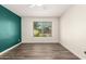 A bedroom with a view of a landscaped yard, wood-look floors, and new paint at 830 E Gila Ln, Chandler, AZ 85225