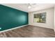 A spacious bedroom with wood-look flooring, a ceiling fan, and a green accent wall at 830 E Gila Ln, Chandler, AZ 85225