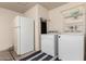 This utility room features a full size refrigerator and stacked washer and dryer at 830 E Gila Ln, Chandler, AZ 85225