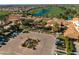 Aerial view of the property showcasing the building's roof, parking lot, garden, landscaping, trees, and golf course at 841 E Farmers Ln, Queen Creek, AZ 85140