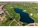 Aerial view of a scenic golf course featuring lush green fairways, a tranquil lake, and sand bunkers at 841 E Farmers Ln, Queen Creek, AZ 85140