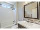 Bathroom with a shower-tub combo, vanity with decorative tile backsplash, and a framed mirror at 841 E Farmers Ln, Queen Creek, AZ 85140