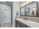 Bright bathroom features dark vanity, a sink with neutral countertop, a modern mirror and a view of the glass shower at 841 E Farmers Ln, Queen Creek, AZ 85140