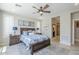 Comfortable bedroom with neutral walls, stylish furniture, ceiling fan and view to the bathroom at 841 E Farmers Ln, Queen Creek, AZ 85140