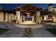 Inviting clubhouse entrance with stone pillars, wooden beams, decorative lighting, and a well-manicured flower bed at 841 E Farmers Ln, Queen Creek, AZ 85140