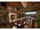 Elegant dining room featuring a fireplace, stone walls, chandelier, and a view of the golf course at 841 E Farmers Ln, Queen Creek, AZ 85140