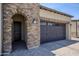 Inviting front exterior with brick archway, stone accents, a paved driveway, and manicured lawn at 841 E Farmers Ln, Queen Creek, AZ 85140