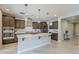 Spacious kitchen with brown cabinets, stainless steel appliances, large island, and stylish pendant lighting at 841 E Farmers Ln, Queen Creek, AZ 85140