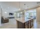 Open-concept kitchen with island, pendant lights, stainless appliances, seamlessly connecting to the living area at 841 E Farmers Ln, Queen Creek, AZ 85140