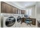 Well-lit laundry room featuring Samsung washer and dryer, dark cabinets, and a convenient built-in desk area at 841 E Farmers Ln, Queen Creek, AZ 85140