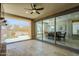 Covered patio with travertine tile flooring, fan, and views of the outdoor dining area at 841 E Farmers Ln, Queen Creek, AZ 85140