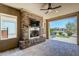 This covered patio features a brick fireplace, ceiling fan, and an opening to the backyard at 841 E Farmers Ln, Queen Creek, AZ 85140
