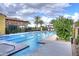 Community pool with lap lanes, palm trees, and outdoor seating area on a partly cloudy day at 841 E Farmers Ln, Queen Creek, AZ 85140
