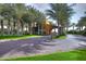 A grand property entrance features towering palm trees, lush green lawns, and a welcoming facade covered in vines at 841 E Farmers Ln, Queen Creek, AZ 85140