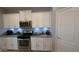 Updated kitchen with white cabinets, stainless steel appliances, granite countertops and decorative backsplash at 8419 S 40Th Dr, Laveen, AZ 85339