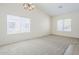 Carpeted living room with multiple bright windows and modern chandelier at 8438 W Bajada Rd, Peoria, AZ 85383