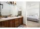 Bathroom featuring dual sinks, a wooden vanity, and a view to the main bedroom at 8896 E Mescal St, Scottsdale, AZ 85260