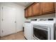 Functional laundry room with modern washer and dryer, complete with upper cabinets for storage, and tile floors at 8896 E Mescal St, Scottsdale, AZ 85260